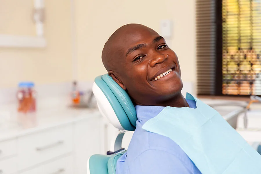 A smiling patient in a dental chair